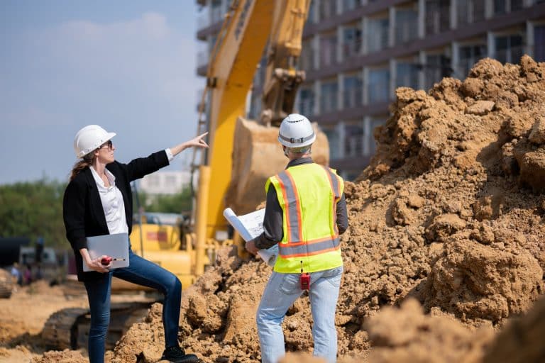 How Design and Construct Services Streamline Commercial Building Projects Construction workers discussing site plans