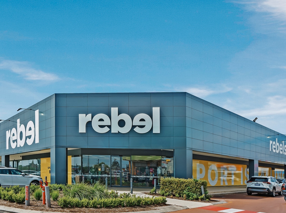 Rebel store exterior with cars and blue sky.